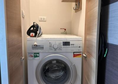 Small laundry area with a front-loading washing machine in a closet