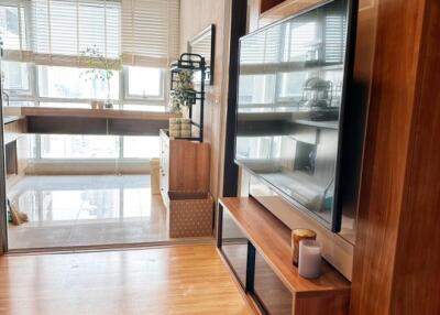 Modern living area with mounted television and adjacent room with large windows