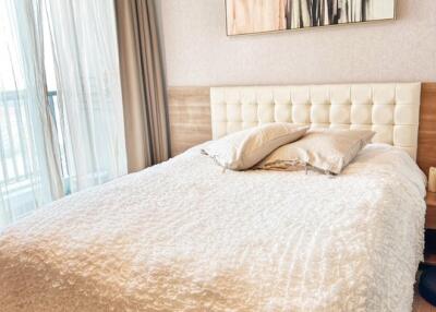 Cozy bedroom with large bed and art piece above the headboard