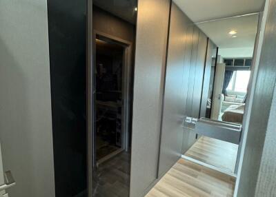 Modern hallway with built-in dark glass wardrobe and wooden flooring