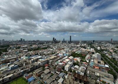 Panoramic view of a city with numerous buildings under a cloudy sky