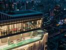 Exterior view of a high-rise building with rooftop swimming pools and cityscape at night