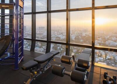 Indoor gym area with city view at sunset