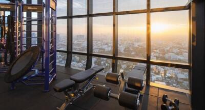 Indoor gym area with city view at sunset