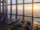 Indoor gym area with city view at sunset