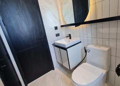 Modern bathroom with round mirror and dark accents