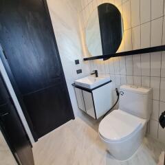 Modern bathroom with round mirror and dark accents