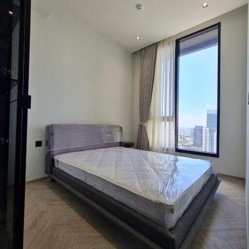 Modern bedroom with large window and city view