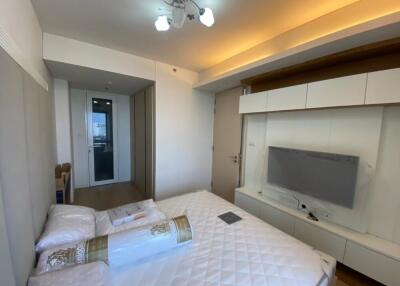 Modern bedroom with built-in storage and wall-mounted TV