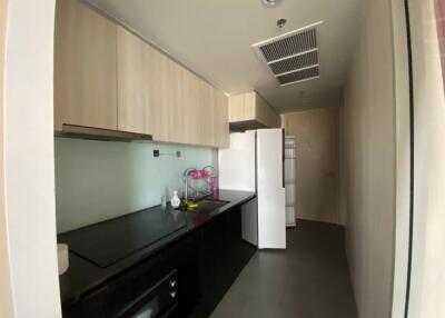 Modern kitchen with black countertop and light wooden cabinets