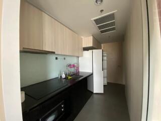 Modern kitchen with black countertop and light wooden cabinets