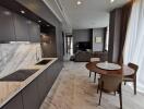 Modern kitchen and open living area with marble countertops and dining table