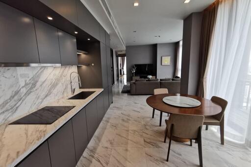 Modern kitchen and open living area with marble countertops and dining table