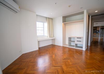 Spacious bedroom with wooden flooring and built-in closet