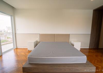 Minimalist bedroom with large windows and balcony access