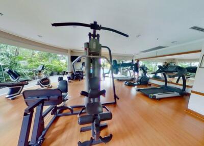 Well-equipped gym with various exercise machines and large windows