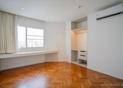 Spacious bedroom with hardwood floors and built-in storage