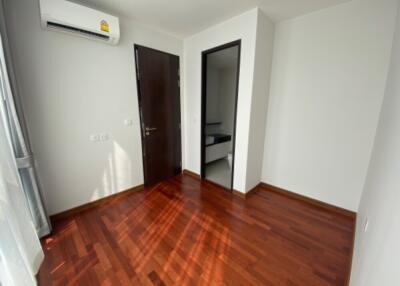 Small empty bedroom with hard wood floors and air conditioner