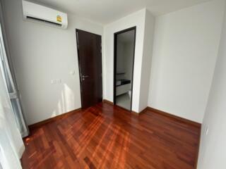 Small empty bedroom with hard wood floors and air conditioner