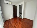 Small empty bedroom with hard wood floors and air conditioner