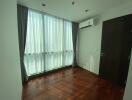 Bedroom with wooden floor and large window