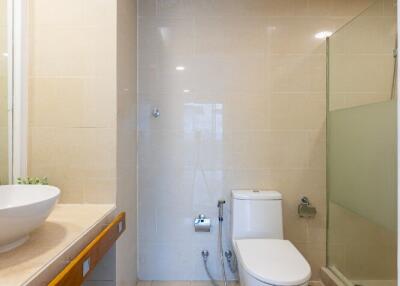 A well-lit bathroom with a modern sink, toilet, and shower