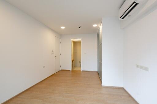 Spacious room with wooden flooring and air conditioning