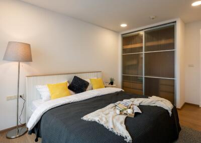 Modern styled bedroom with double bed, side lamp, and sliding door wardrobe