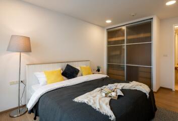 Modern styled bedroom with double bed, side lamp, and sliding door wardrobe