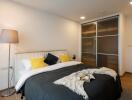 Modern styled bedroom with double bed, side lamp, and sliding door wardrobe