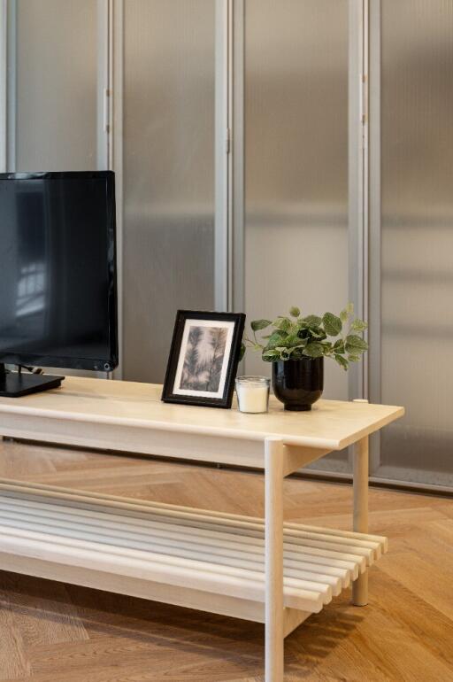 Living room with coffee table, TV, and decorative items