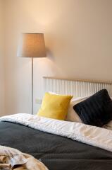 Cozy bedroom with colorful cushions and a standing lamp