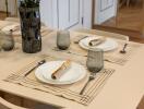 Dining table set with plates, cutlery, and glasses