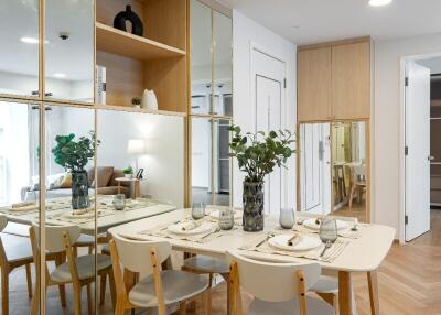 Modern dining area with white table, chairs, and mirrored walls