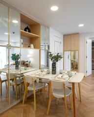 Modern dining area with white table, chairs, and mirrored walls