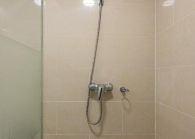 Shower area with beige tiles