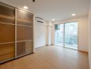 Bright and spacious living area with sliding door wardrobe and balcony access