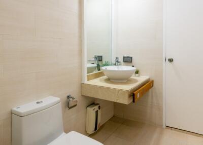 Modern bathroom with toilet, sink, and mirror