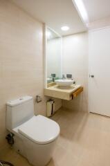 Modern bathroom with toilet, sink, and mirror