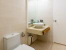 Modern bathroom with toilet, sink, and mirror