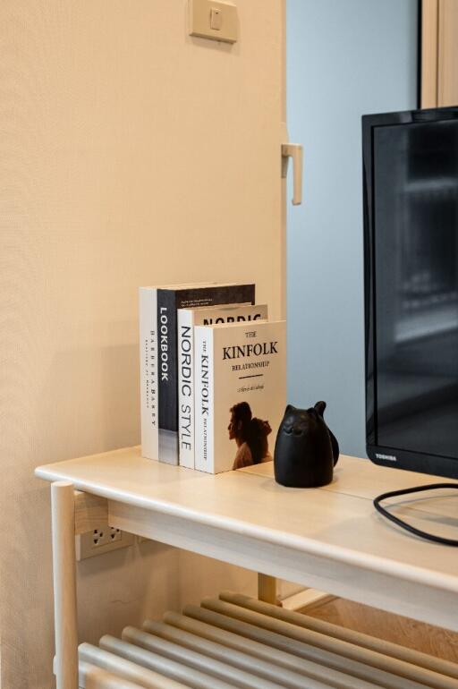 Close-up view of a side table in the living room with books and a TV