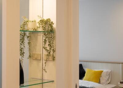 View of bedroom with a glimpse through an illuminated shelf display