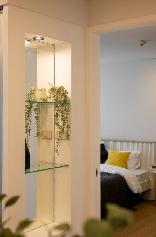 View of bedroom with a glimpse through an illuminated shelf display