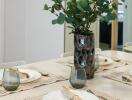 Dining table set with plates, utensils, and a decorative plant