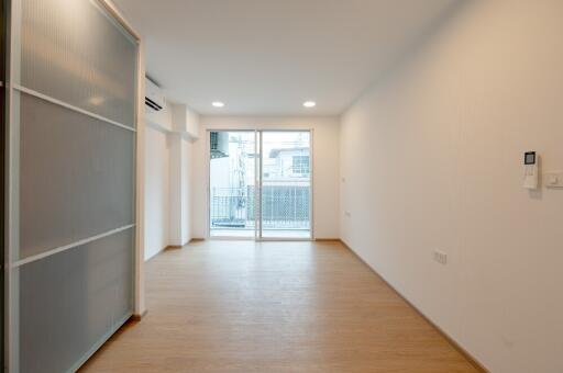 Minimalist living room with wooden floor and glass sliding doors