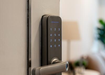 Close-up of a modern electronic door lock leading into a living space