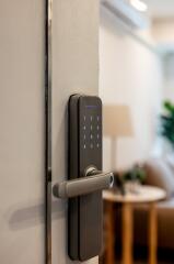 Close-up of a modern electronic door lock leading into a living space