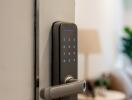 Close-up of a modern electronic door lock leading into a living space