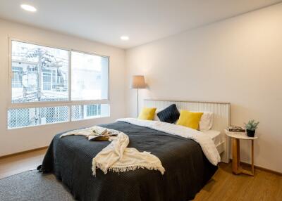 Cozy bedroom with large bed, window, and bedside table