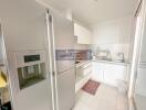 Modern kitchen with stainless steel refrigerator and white cabinets